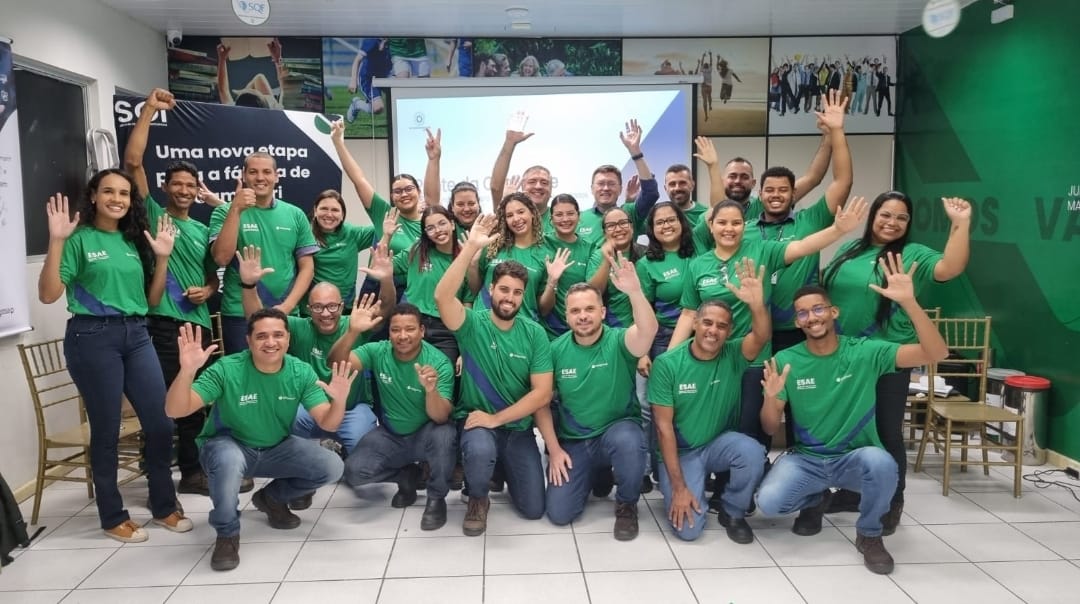 Turma de treinamento de uniforme verde acenando para a foto